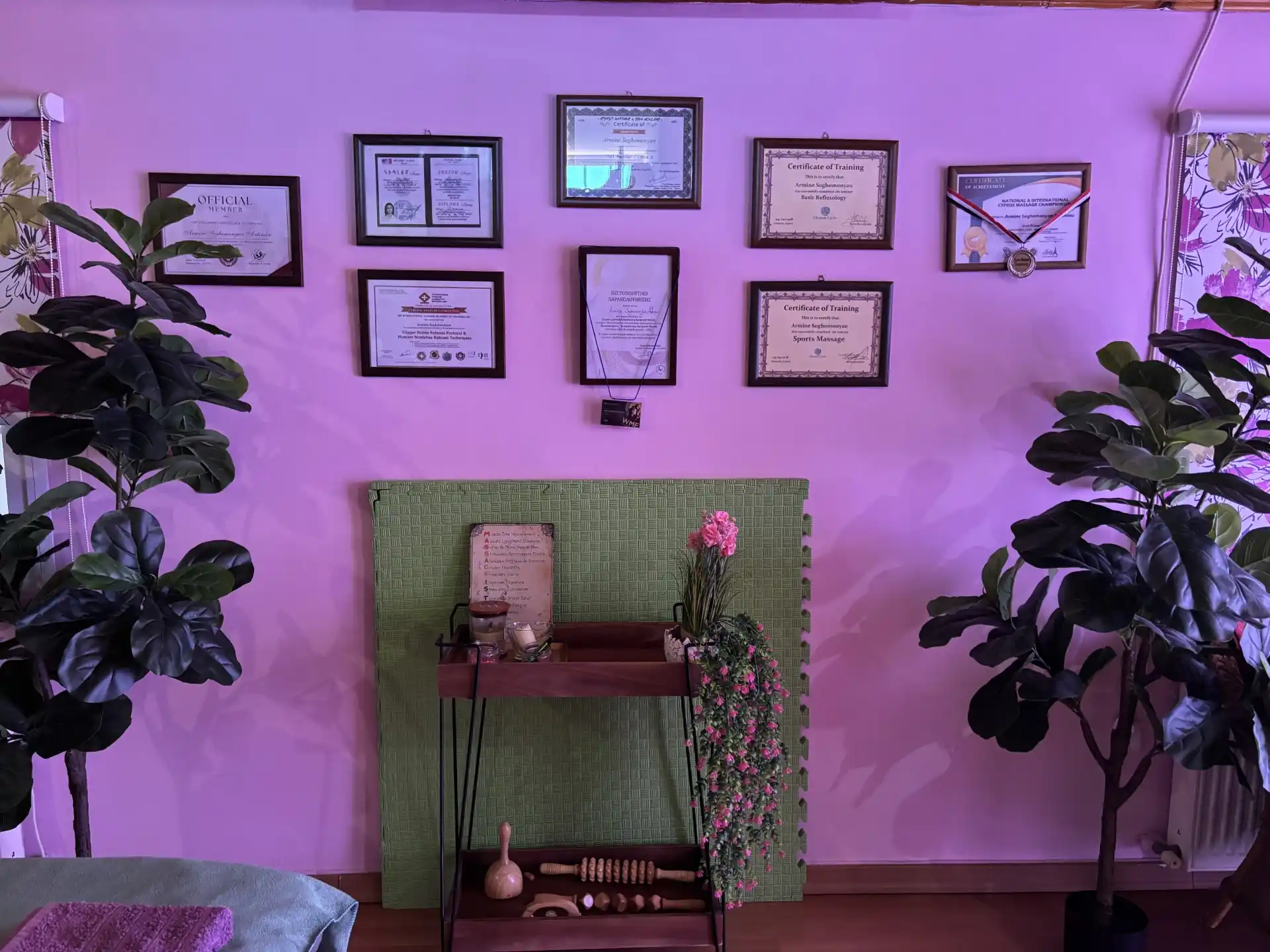 Wall displaying professional massage therapy certifications and diplomas